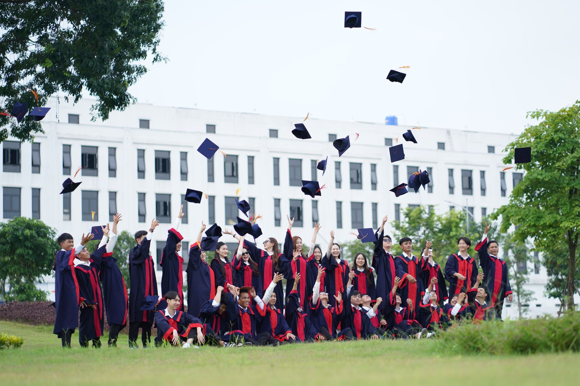 Graduates throwing their caps in the air outside a university building