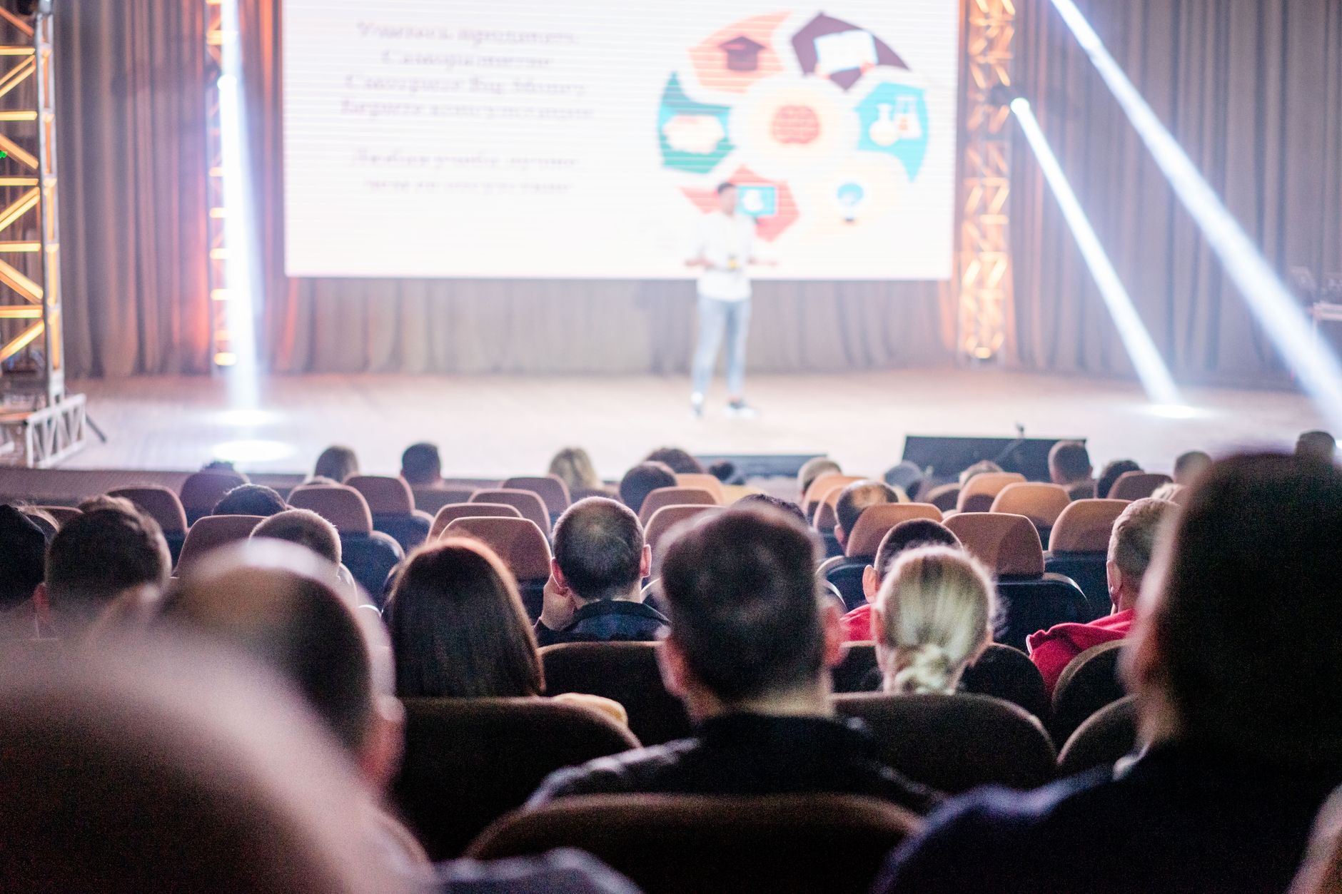 Audience watching a speaker on stage at a conference